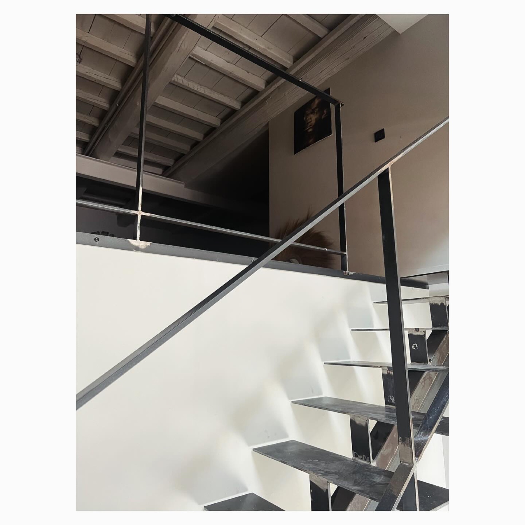Escalier en acier noir sous charpente bois — Casa Jungle