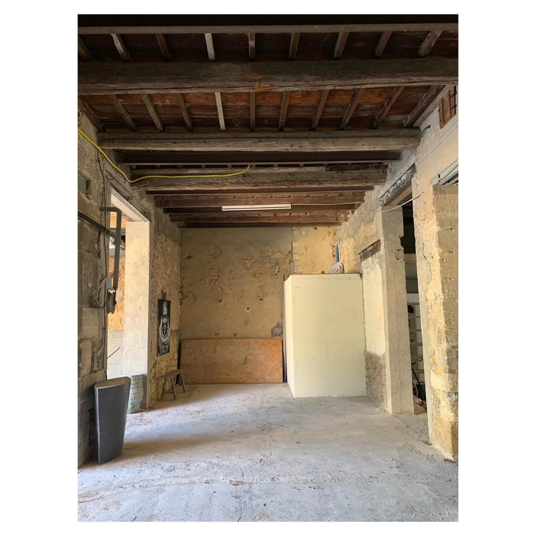 Chantier en cours : volumes bruts, pierres et poutres apparentes avant rénovation