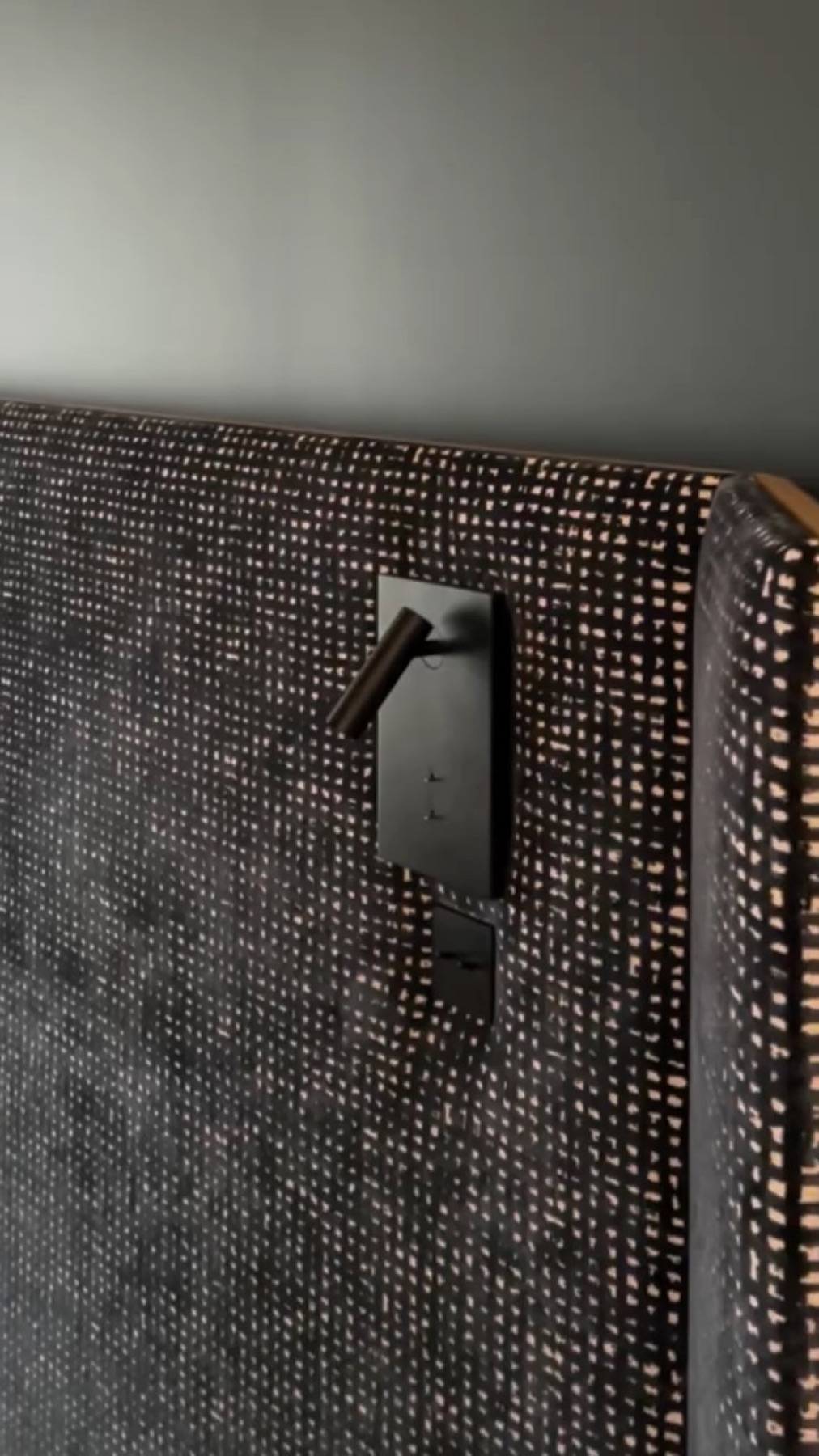 Détail d'une tête de lit en tissu et liseuse noire sur-mesure